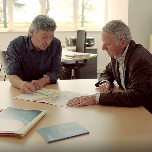 Gouvernance - deux hommes autour d'une table étudient un dossier